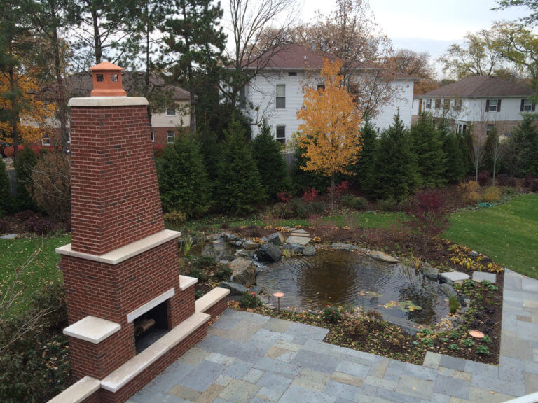 outdoor fireplace and backyard pond of the Haven Home in Wheaton, IL